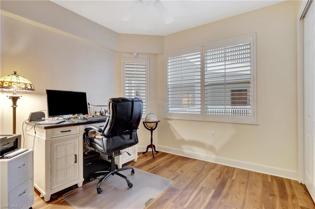 Office area with light wood-type flooring and ceiling fan