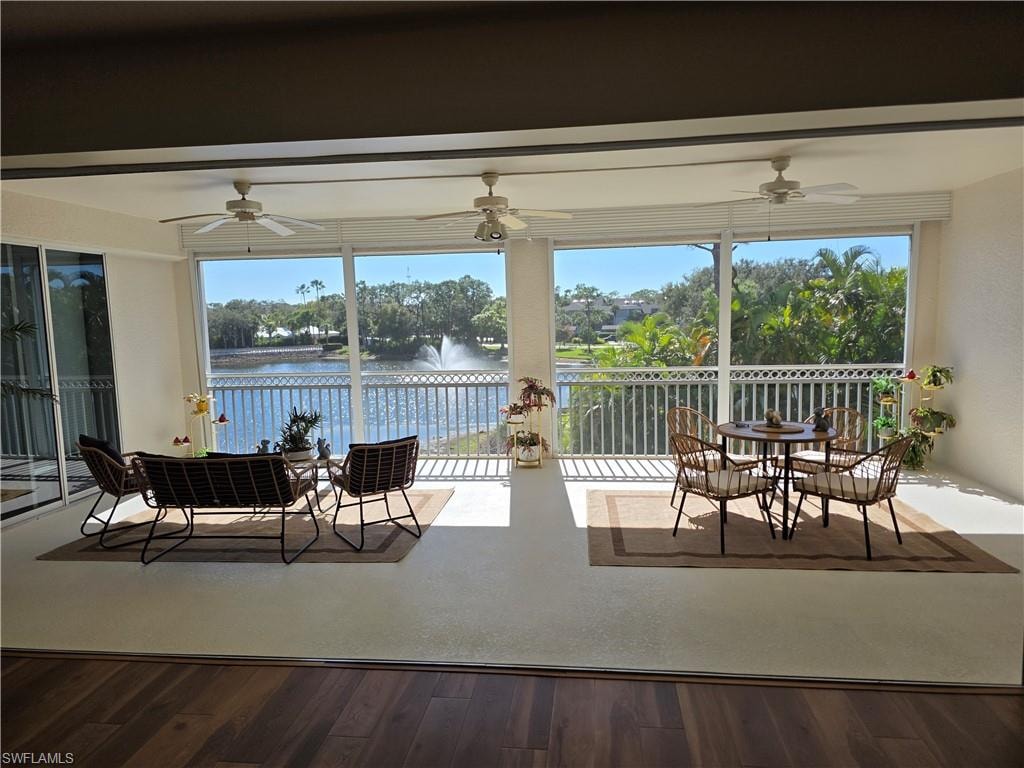 View of patio / terrace with a sunroom, outdoor dining area, a water view, and ceiling fan