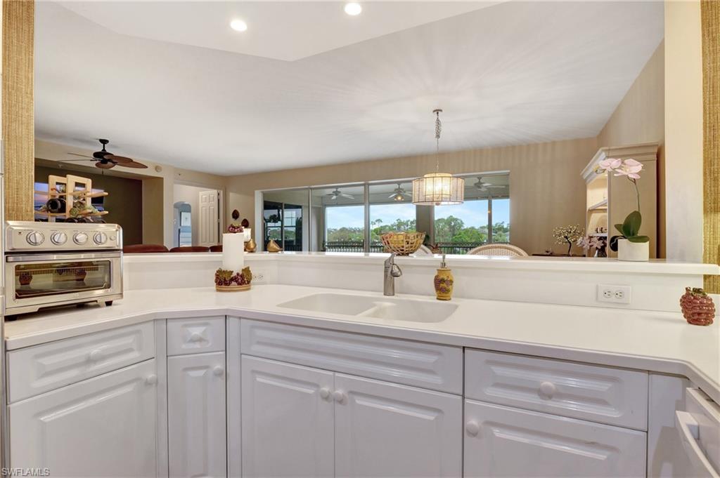 Kitchen featuring white cabinets, ceiling fan, recessed lighting, and decorative light fixtures