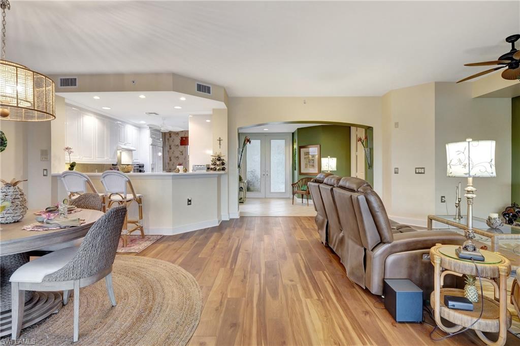 Living room featuring arched walkways, light wood-style floors, recessed lighting, french doors, and ceiling fan