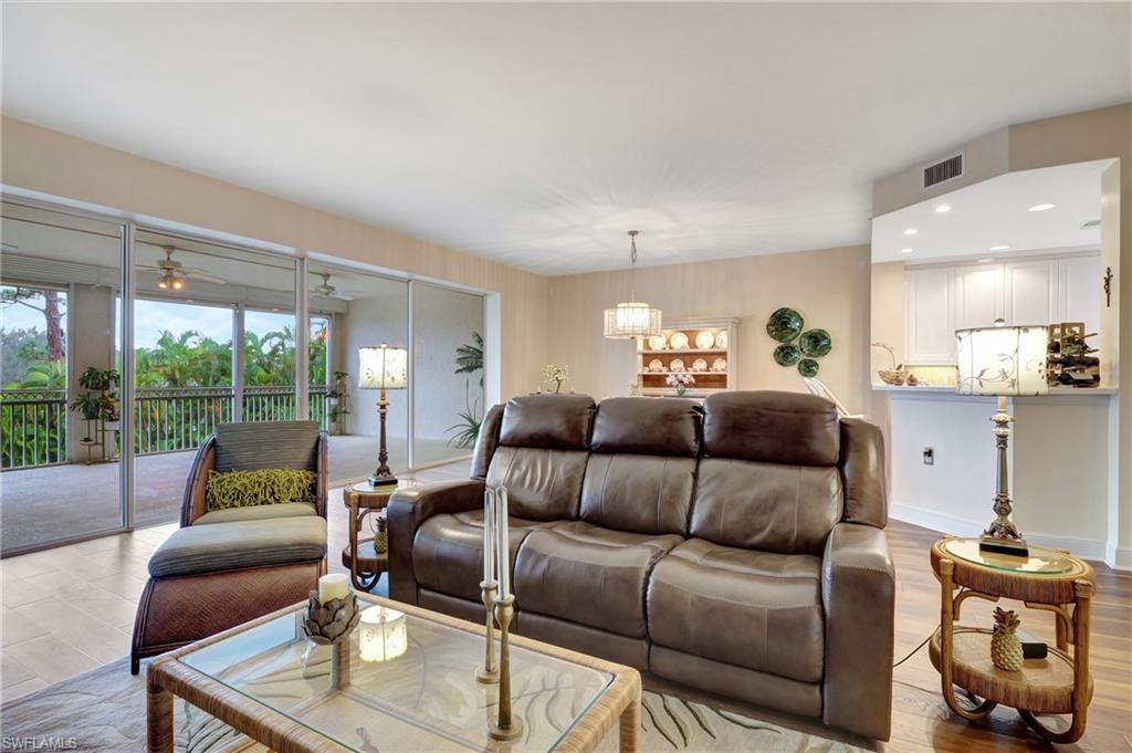 Living room with light wood finished floors, ceiling fan, and recessed lighting