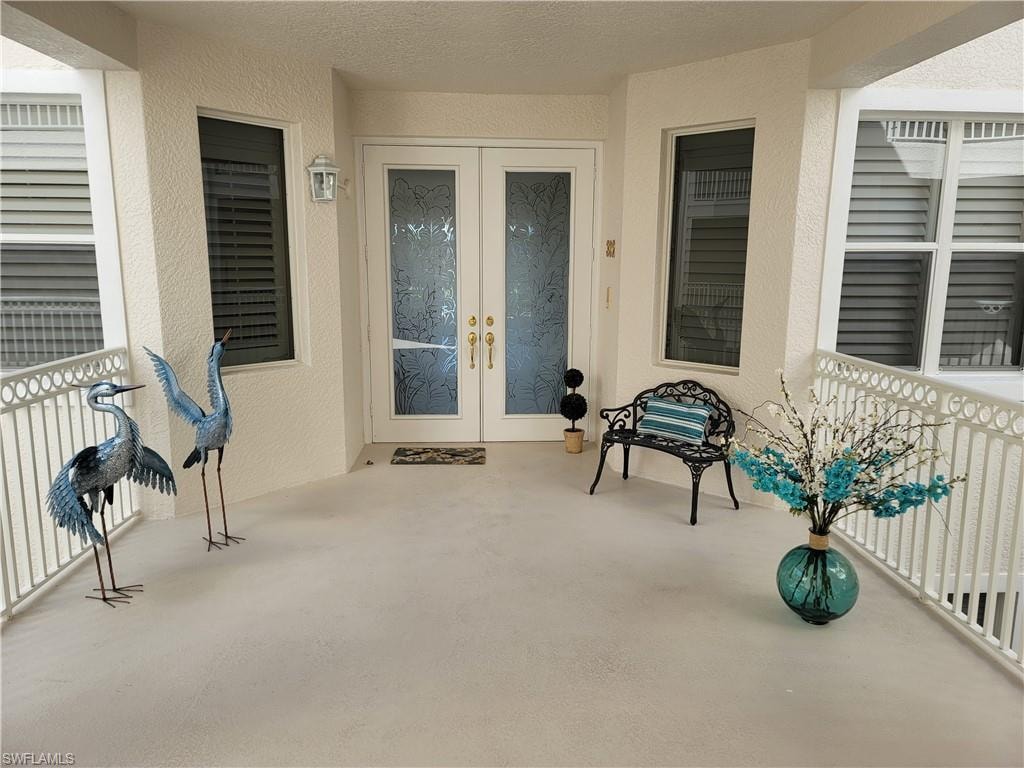 Doorway to property featuring french doors and stucco siding