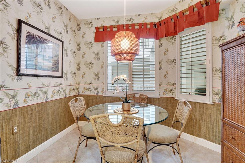 Dining space with wallpapered walls and light tile patterned floors
