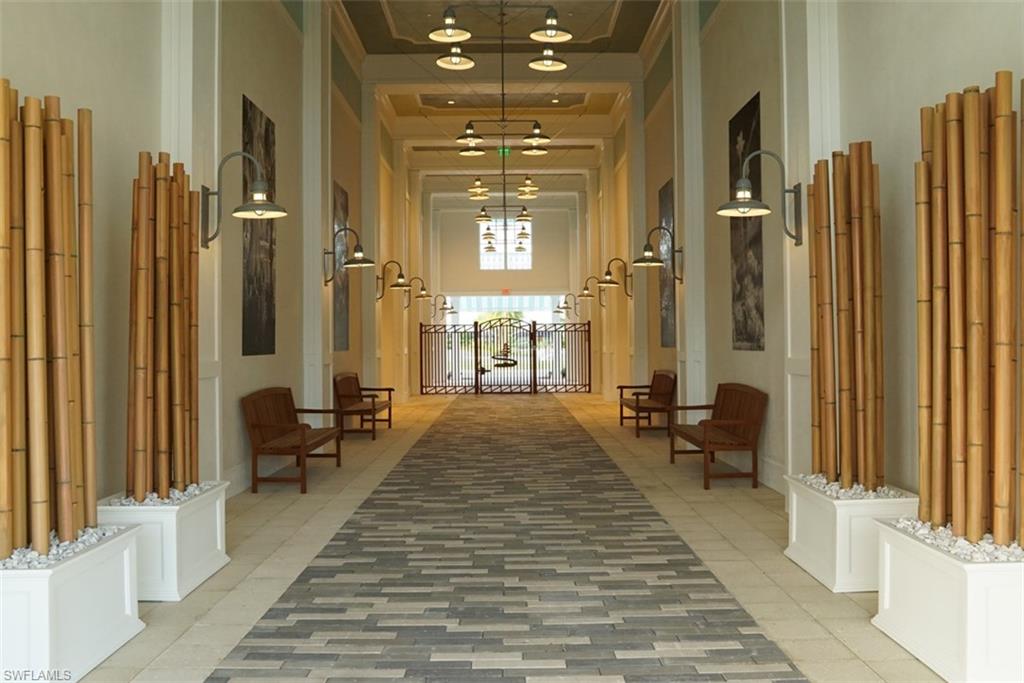 Hallway featuring an inviting chandelier, a high ceiling, and a tray ceiling