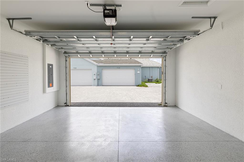 Garage with electric panel and a garage door opener