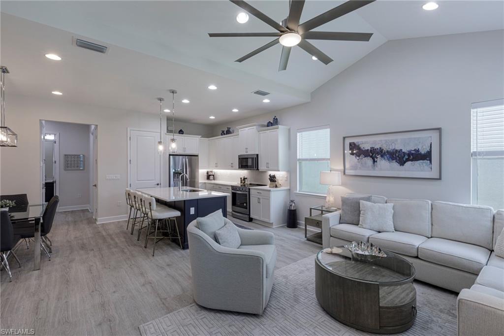 Living area featuring a ceiling fan, light wood-style floors, recessed lighting, and lofted ceiling