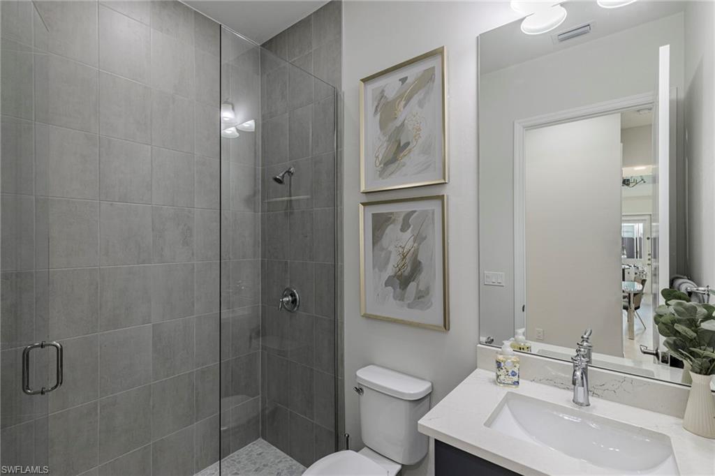 Bathroom with a shower with door, toilet, and vanity