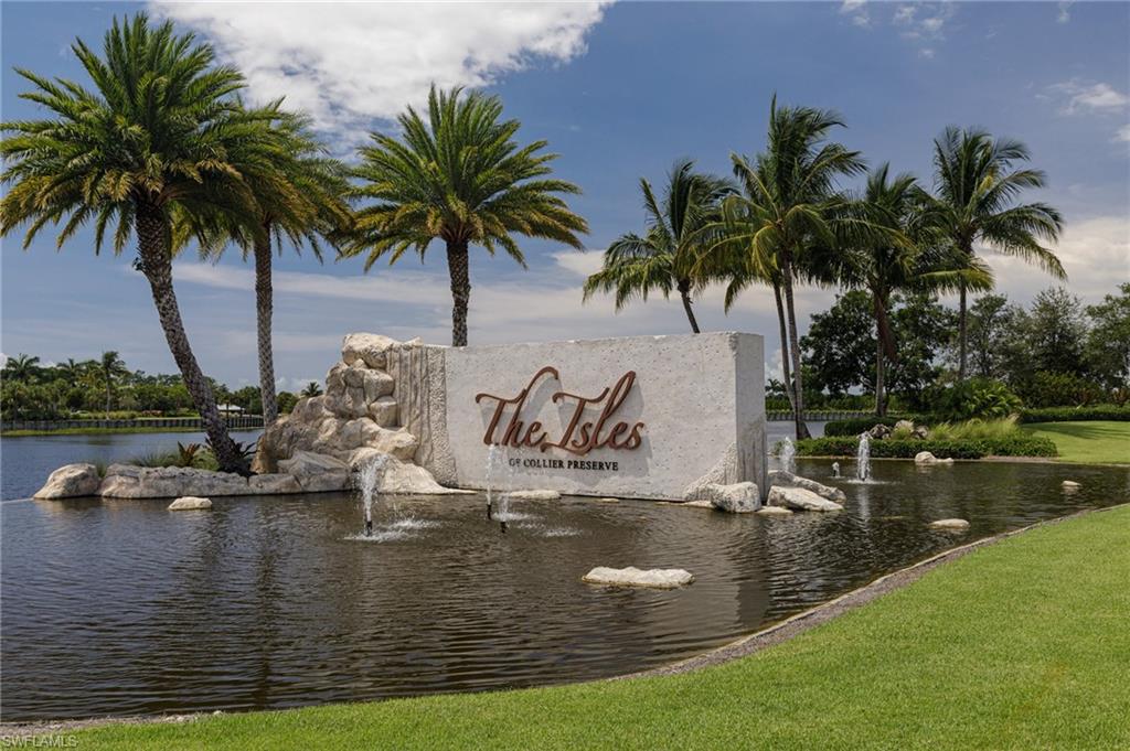 Community / neighborhood sign with a water view and a lawn