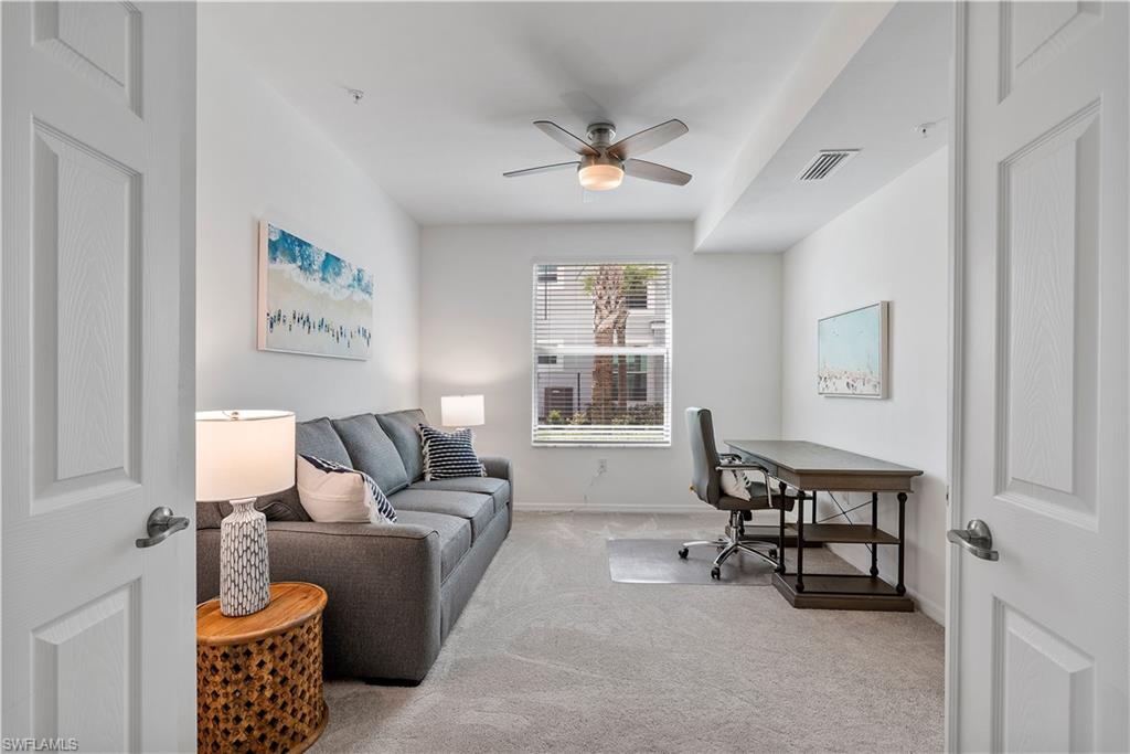 Office space with light carpet and a ceiling fan