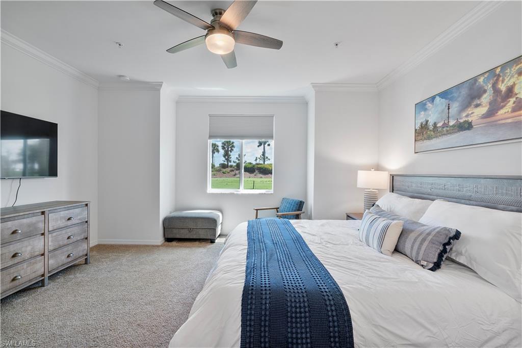 Bedroom featuring ornamental molding, light carpet, and a ceiling fan