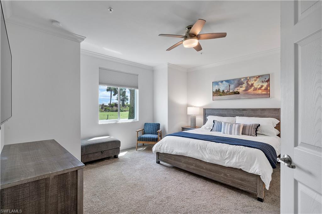 Carpeted bedroom featuring crown molding and ceiling fan