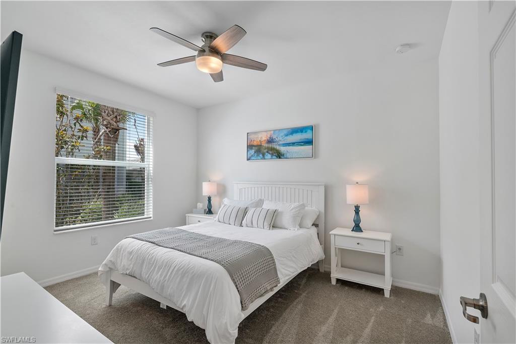 Carpeted bedroom with baseboards and a ceiling fan