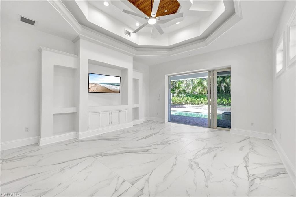 Ground floor primary bedroom featuring built in cabinets, light marble finish floors, ceiling fan, recessed lighting and sliding door to pool area.