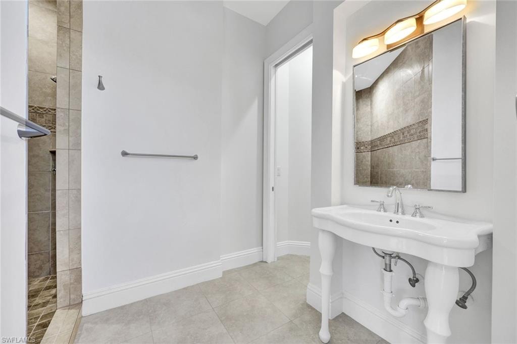 Middle guest-bathroom with walk in shower and vanity sink.