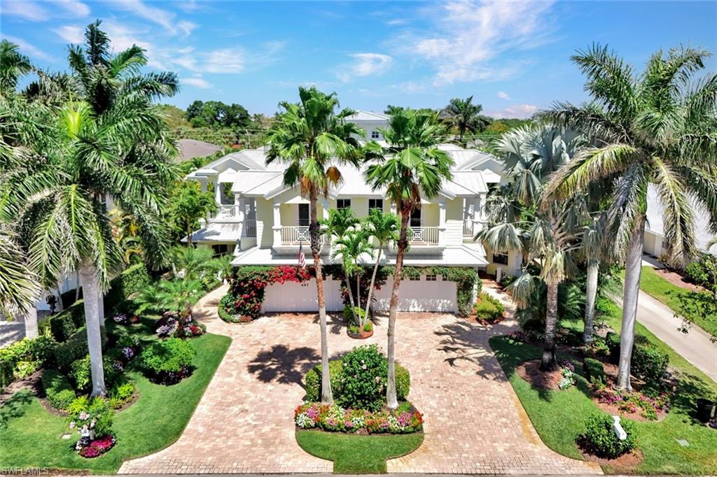 Drone view of the home, paved driveway and balcony.