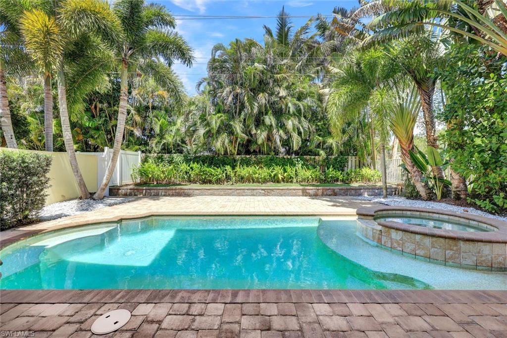 View of swimming pool with a patio area, a fenced backyard, and a pool with connected hot tub