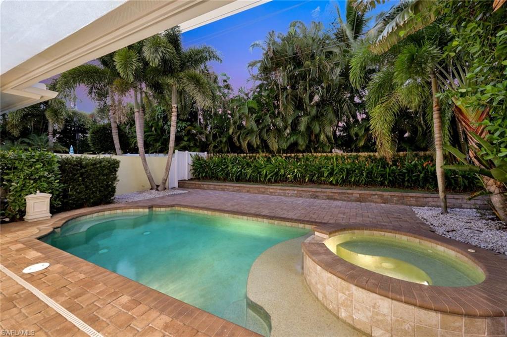 Rear view of property featuring a balcony, a pool with connected hot tub, a patio, and a ceiling fan
