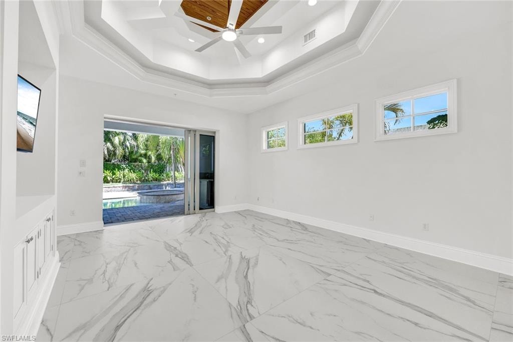Spacious primary guest suite with sliding door to back lanai and pool area