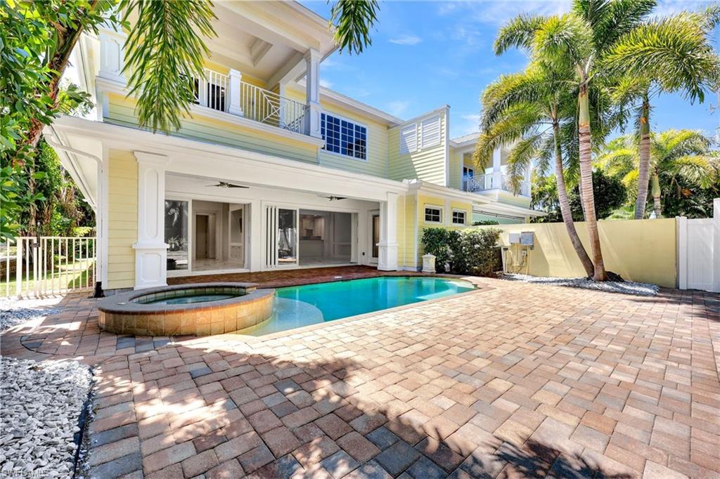 View of pool with a balcony, ceiling fan, a patio area, and a pool with connected hot tub