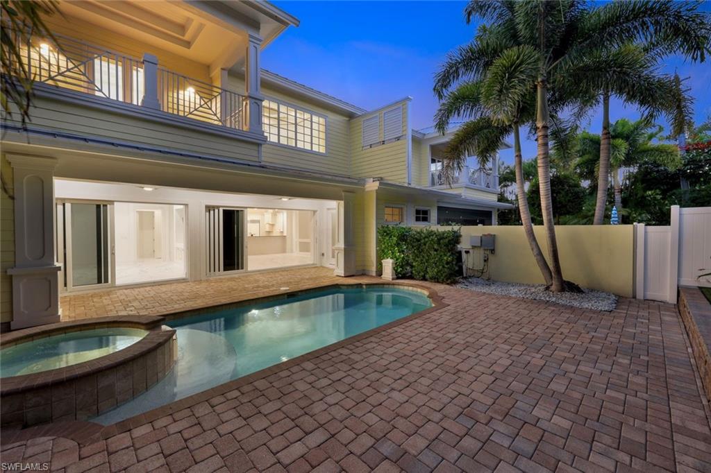 View of swimming pool featuring a fenced backyard, a patio, and a pool with connected hot tub