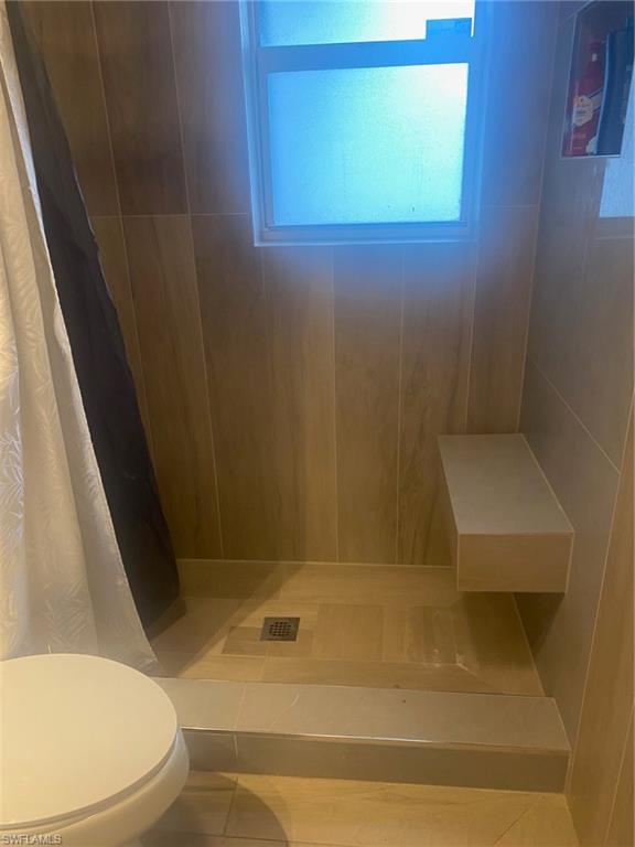 Bathroom featuring a shower with shower curtain and tile patterned flooring