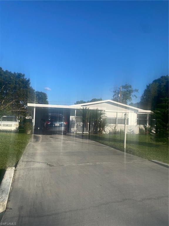 View of front of property featuring driveway and an attached carport