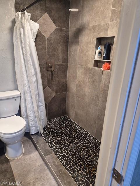 Bathroom with a shower stall and toilet