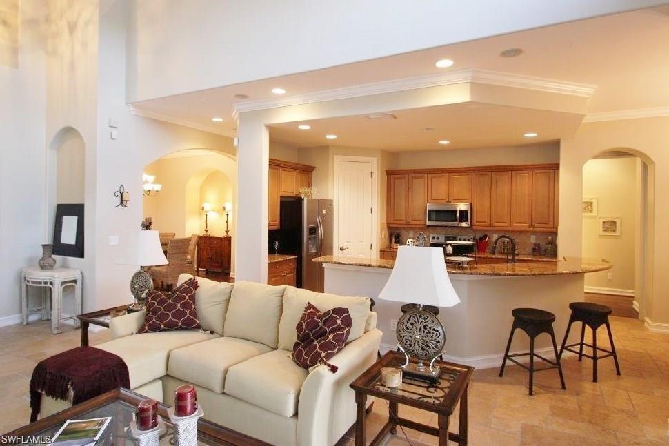 Living room with arched walkways, crown molding, and recessed lighting