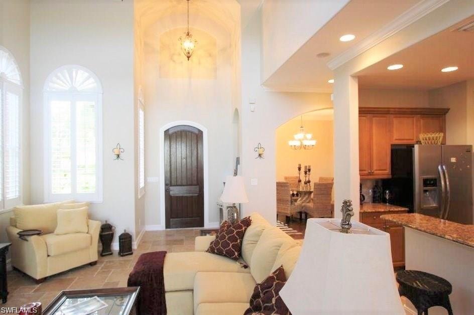 Living room featuring a chandelier, arched walkways, and recessed lighting