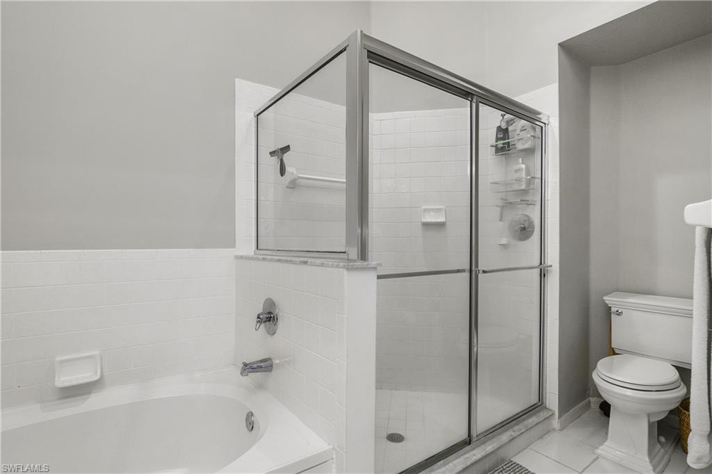 Full bathroom with a bath, light tile patterned flooring, and a shower stall
