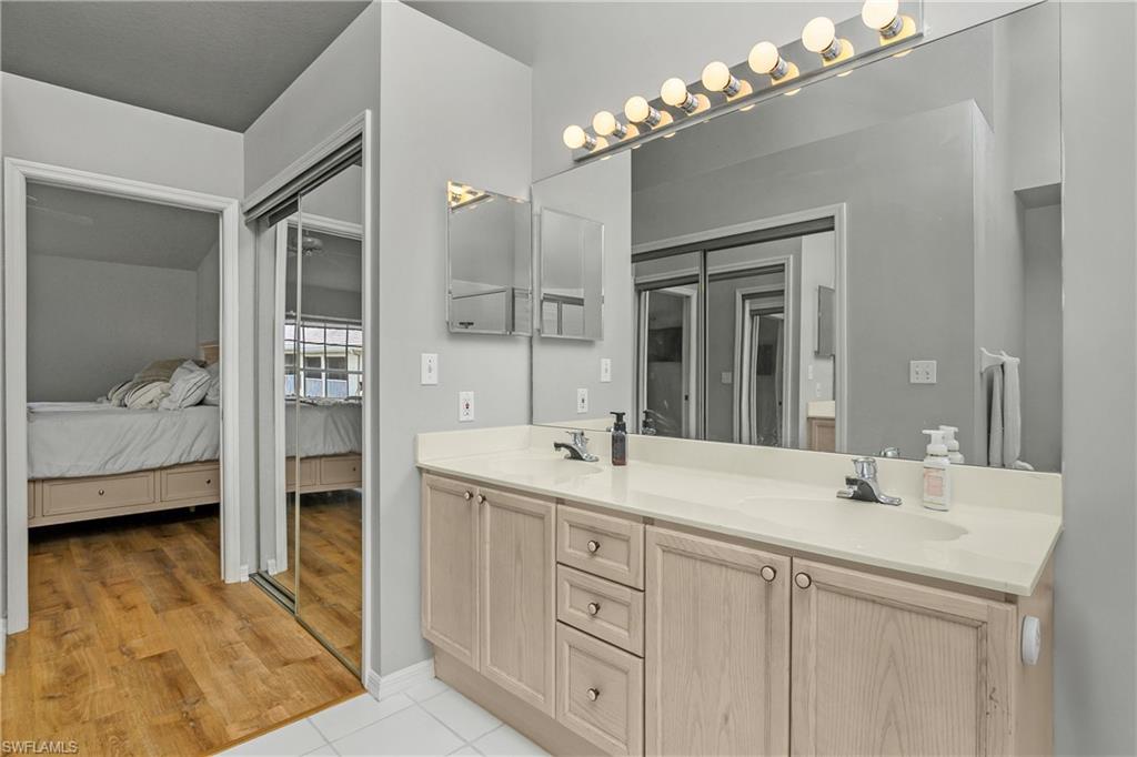 Ensuite bathroom featuring double vanity and light tile patterned floors
