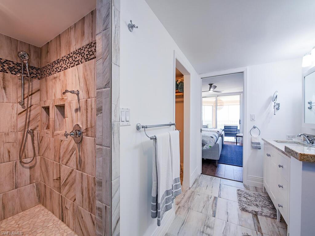 Full bathroom featuring ensuite bathroom, vanity, and tiled shower
