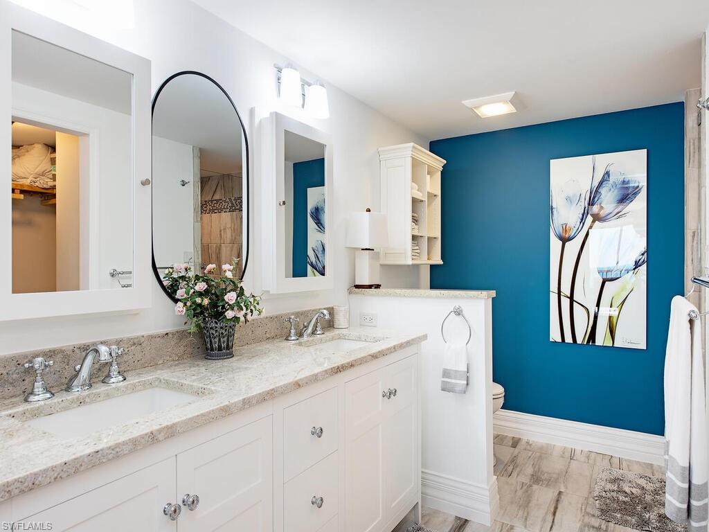 Bathroom featuring double vanity, a walk in closet, and a shower