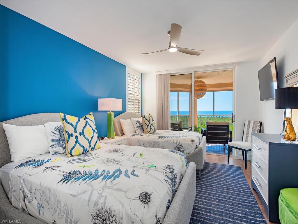Bedroom featuring access to exterior, wood finished floors, floor to ceiling windows, and a ceiling fan
