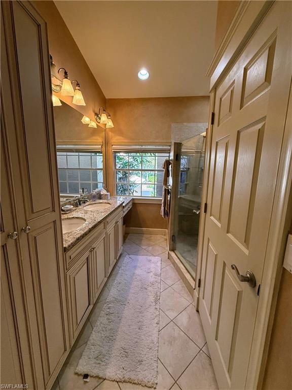 Bathroom with double vanity, light tile patterned flooring, a stall shower, and recessed lighting