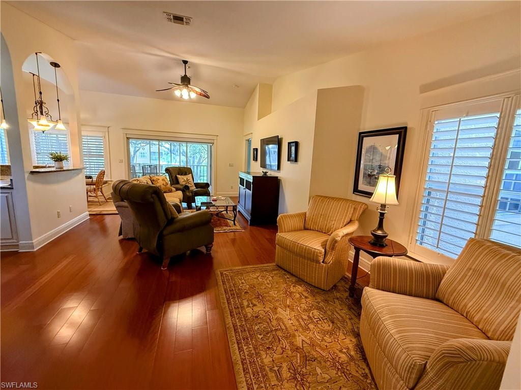 Living room with vaulted ceiling, hardwood / wood-style flooring, ceiling fan, and plenty of natural light