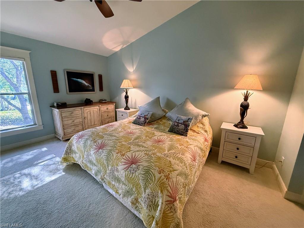 Bedroom with light colored carpet and a ceiling fan