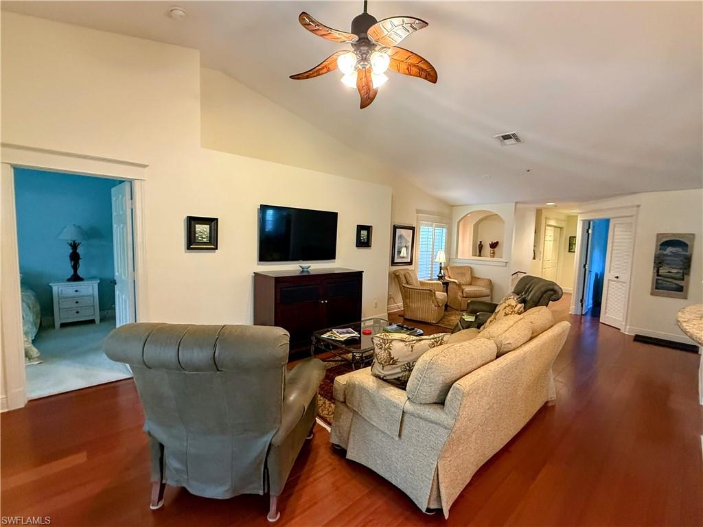 Living room with lofted ceiling, wood finished floors, and ceiling fan