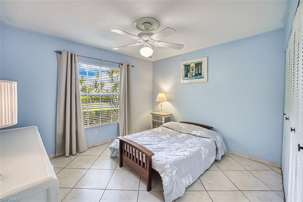Bedroom featuring light tile patterned floors, a closet, and ceiling fan