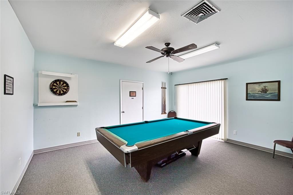 Rec room with pool table, carpet flooring, a ceiling fan, and a textured ceiling