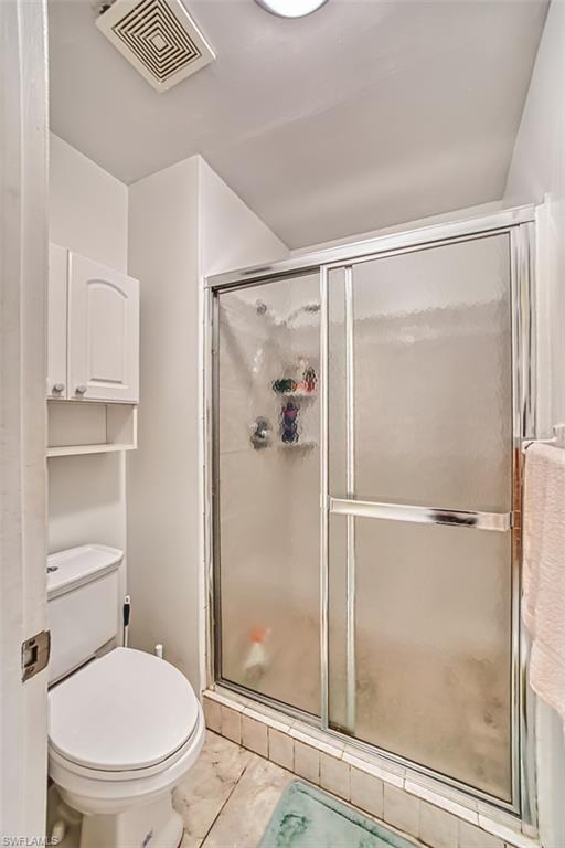 Full bathroom featuring a shower stall and toilet