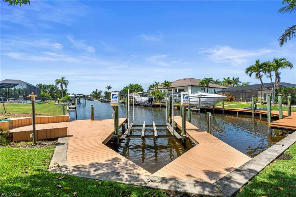 Dock area with boat lift, a water view, and a residential view