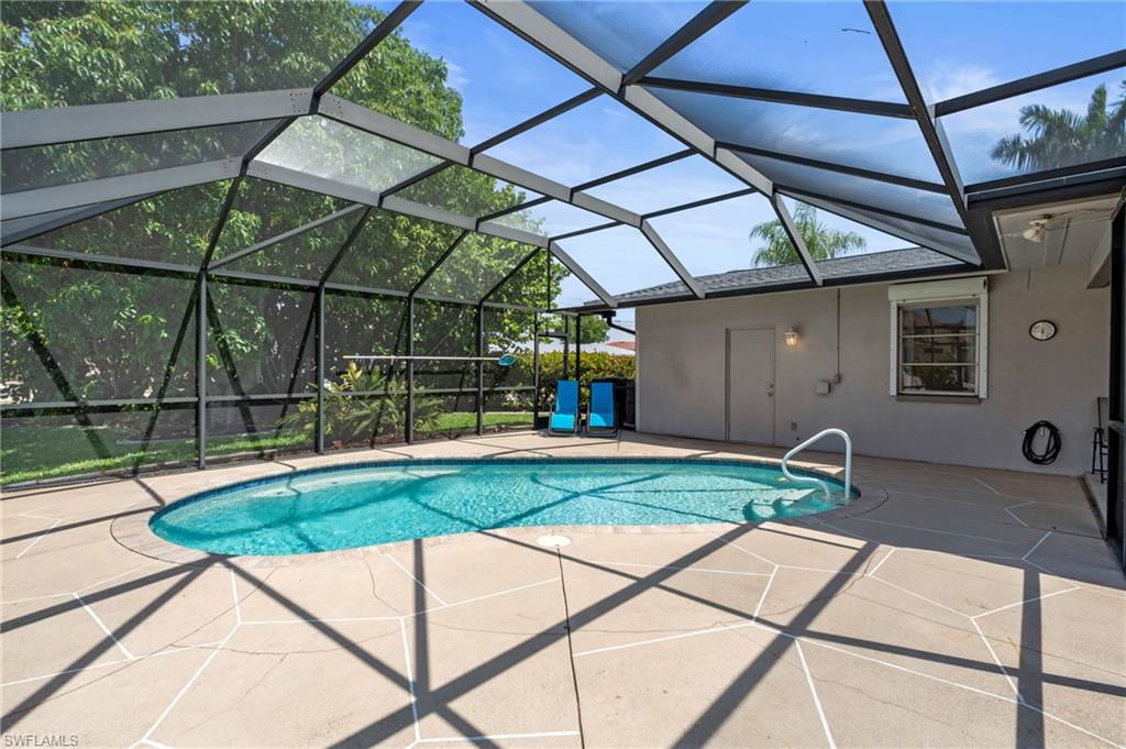 Outdoor pool featuring glass enclosure, a sunroom, and a patio