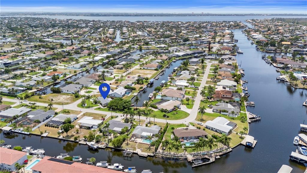 Aerial view of property's location with a large body of water and nearby suburban area