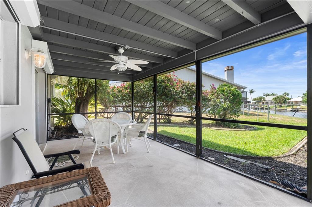 Sunroom with a ceiling fan, a water view, and plenty of natural light