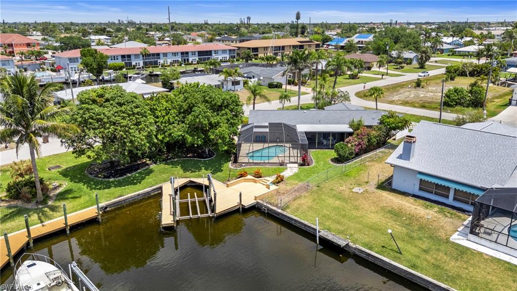 Aerial perspective of suburban area featuring a large body of water and a pool