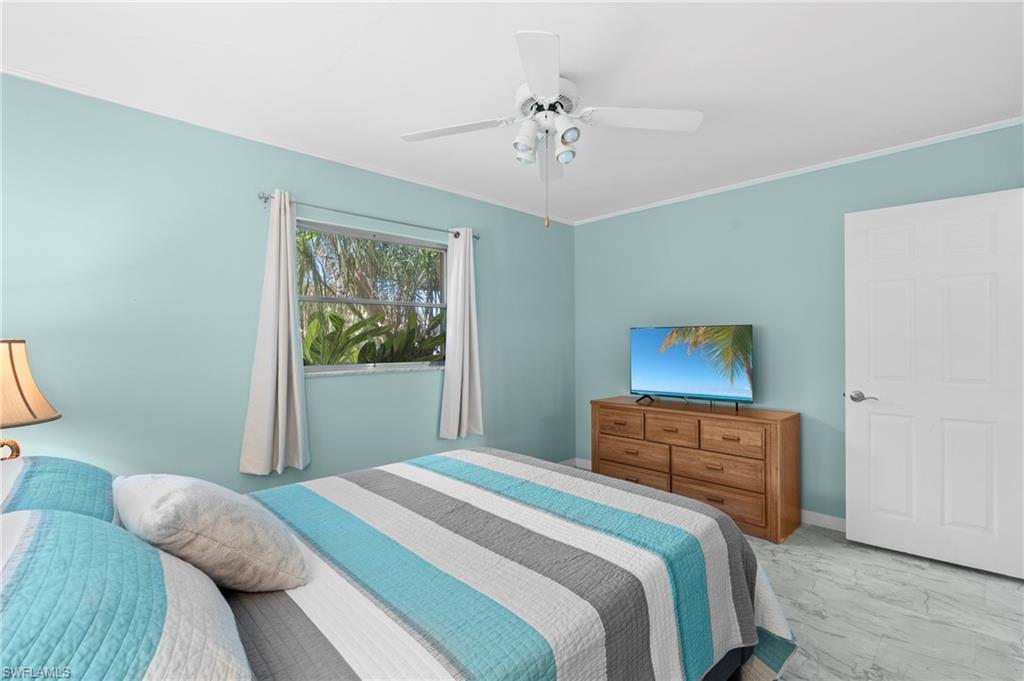 Bedroom with ceiling fan and crown molding