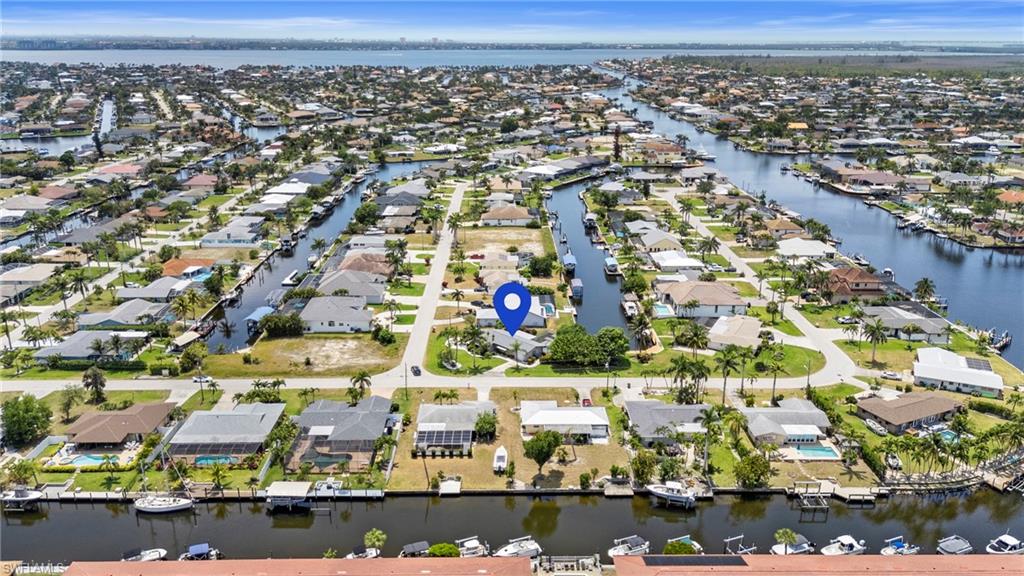 Aerial view of property's location with a nearby body of water and nearby suburban area