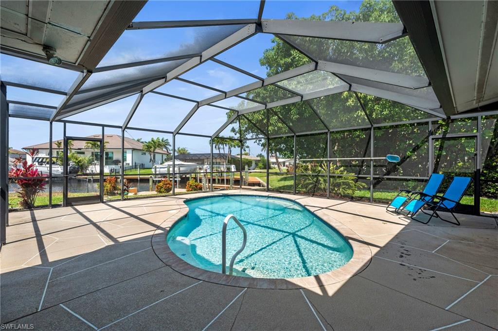 Swimming pool with a lanai, a sunroom, and a patio area