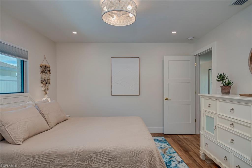 Bedroom featuring dark wood-style floors, recessed lighting, and a chandelier